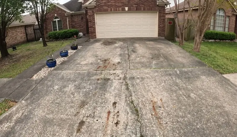 Stained Concrete Driveway Being Pressure Washed in Plant City, FL Stained concrete driveway before cleaning