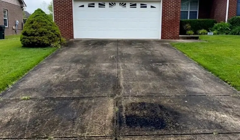 Concrete Driveway Cleaning Job Underway at a Plant City Home Red clay stained driveway before pressure washing