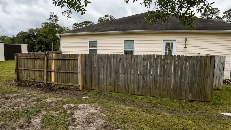 Wood Privacy Fence Being Soft Washed at a Plant City Home Job Site Mildew stained fence before cleaning