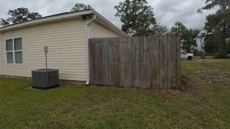 Fence line with mildew staining before a cleaning visit